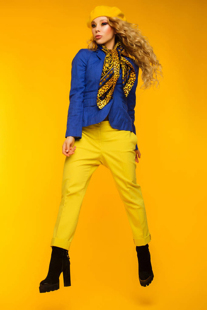 Modefoto. Blondine mit gelber Baskenmütze in blauer Jacke und gelbem Hemd - Foto, Bild