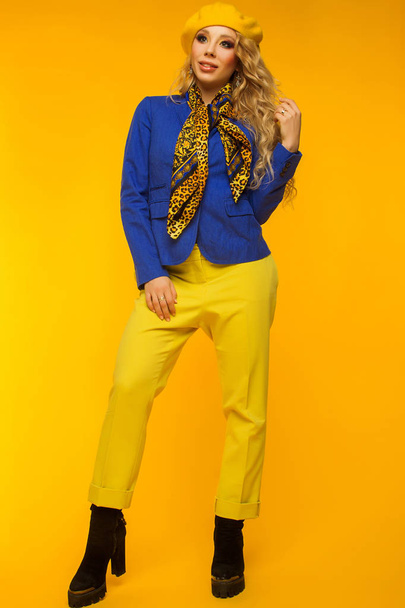 foto de moda. loira em uma boina amarela em uma jaqueta azul e yel
 - Foto, Imagem