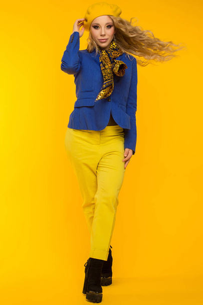 foto de moda. loira em uma boina amarela em uma jaqueta azul e yel
 - Foto, Imagem