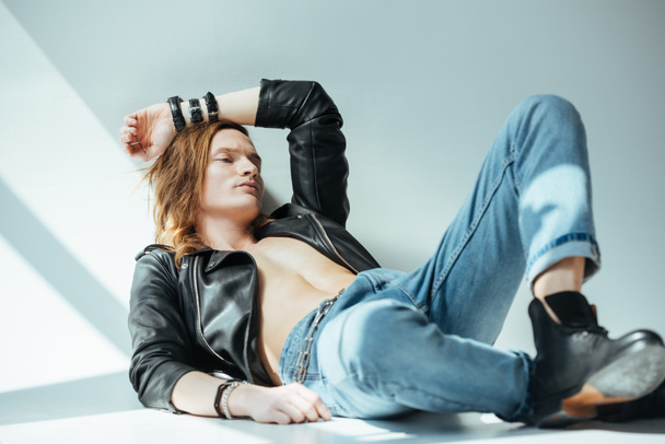shirtless sexy man in jeans and black leather jacket, on grey - Fotoğraf, Görsel