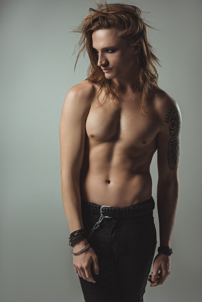 sexy shirtless male model posing in black jeans, isolated on grey - Photo, Image