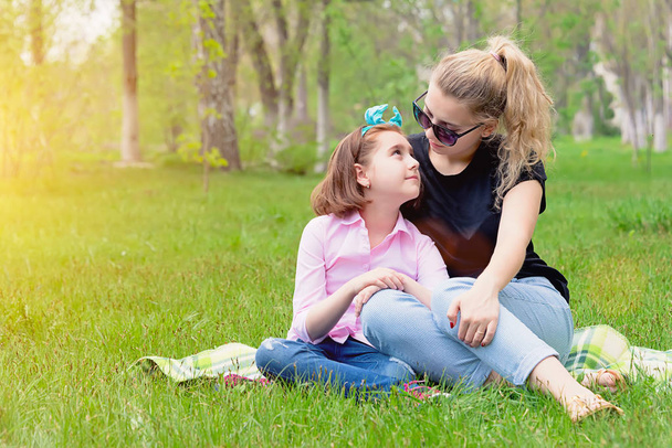 mom and daughter have a rest on the nature on green grass - Photo, Image