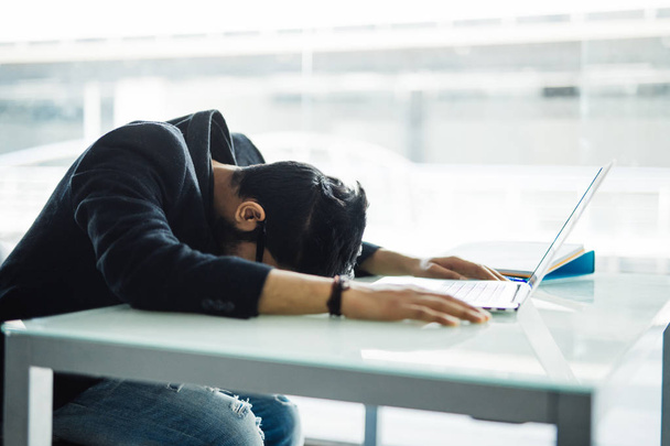Indyjski biznesmen śpiące nad laptopa w nowoczesnym biurze - Zdjęcie, obraz