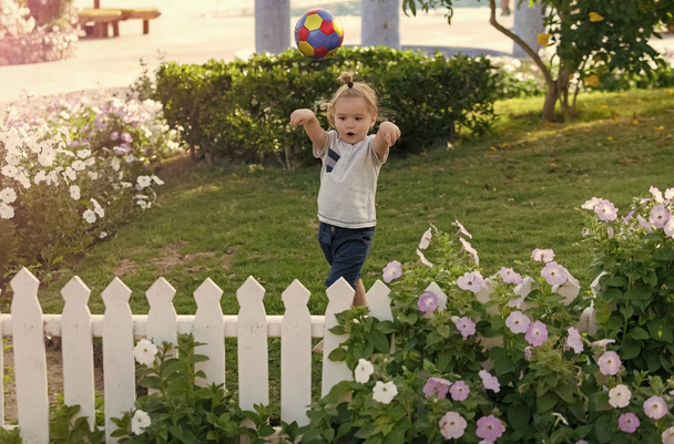 Kid in garden with blossoming flowers - Foto, immagini