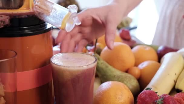 A woman's hand removes a glass with juice from a juicer. - Footage, Video