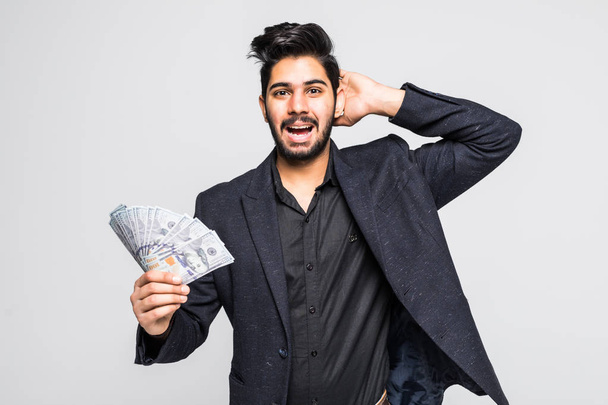 Detailní portrét super šťastný vzrušený úspěšný mladý muž drží peníze dolarové bankovky v ruce, izolovaných na bílém pozadí. výraz obličeje pocit pozitivní emoce. úspory finanční odměnu - Fotografie, Obrázek