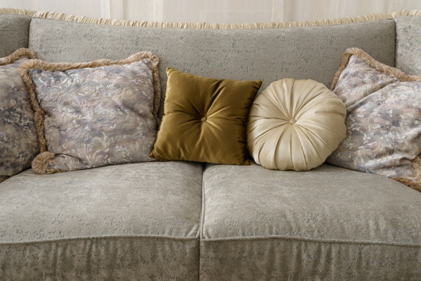 Оксамитові подушки на сірому дивані в кімнаті
 - Фото, зображення