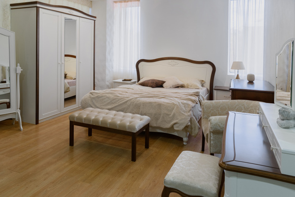 Ελαφριά σεντόνια στο κρεβάτι με άνετο υπνοδωμάτιο με καθρέφτη - Φωτογραφία, εικόνα