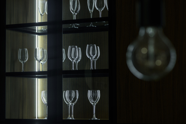 Άδειο καθαρά ποτήρια οργανώνονται σε ξύλινο ντουλάπι - Φωτογραφία, εικόνα