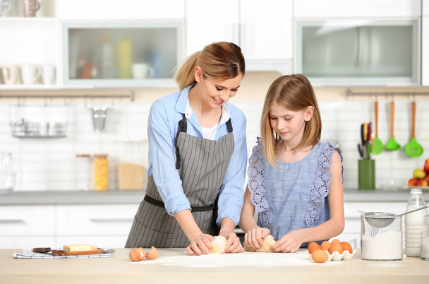 mother and daughter kneading dough  - Foto, Bild