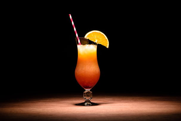 ízletes koktél, narancslé, narancs szelet és a szívószálat a táblázat alkohol - Fotó, kép