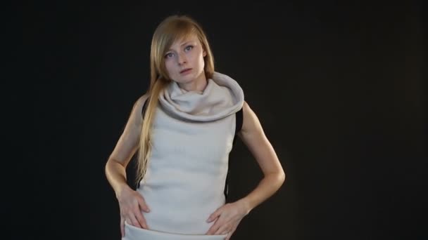 blonde model van Europees uiterlijk poseren voor de camera in een studio op zwarte achtergrond - Video