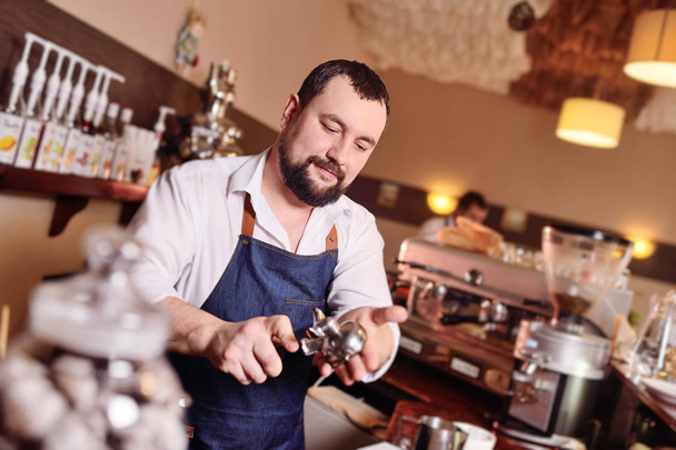 şirin bir tutucu çekilmiş kahve ile tutarak barista adam sakallı - Fotoğraf, Görsel