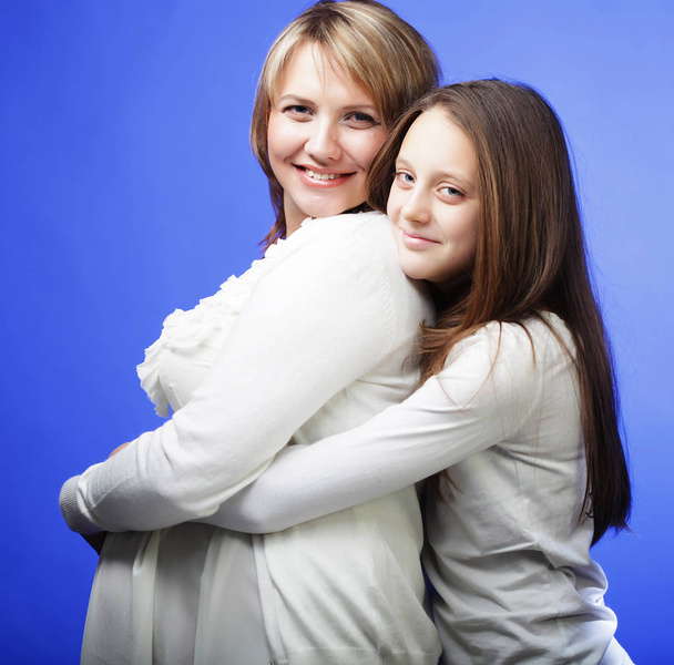 lifestyle, family and people concept: pregnant woman and her daughter - Foto, Imagen