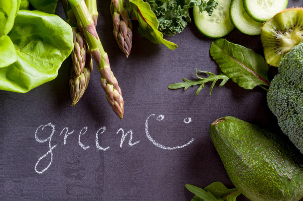 Verduras verdes en pizarra negra con palabra de inscripción verde
. - Foto, imagen