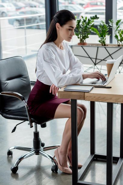 beautiful young businesswoman using laptop at workplace - Photo, Image