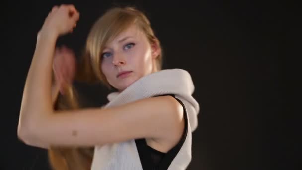 blondi malli Euroopan ulkonäkö poseeraa kameran edessä studiossa mustalla taustalla
 - Materiaali, video