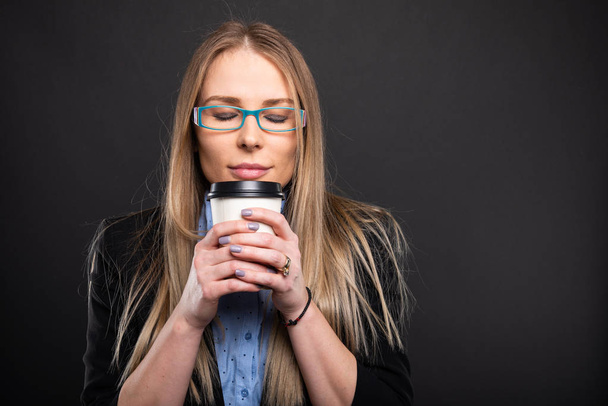 Senhora de negócios vestindo óculos azuis cheirando café para g
 - Foto, Imagem
