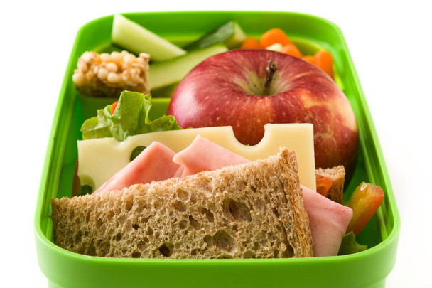 Gezonde school lunch: Sandwich, groenten, fruit en SAP geïsoleerd op witte achtergrond - Foto, afbeelding