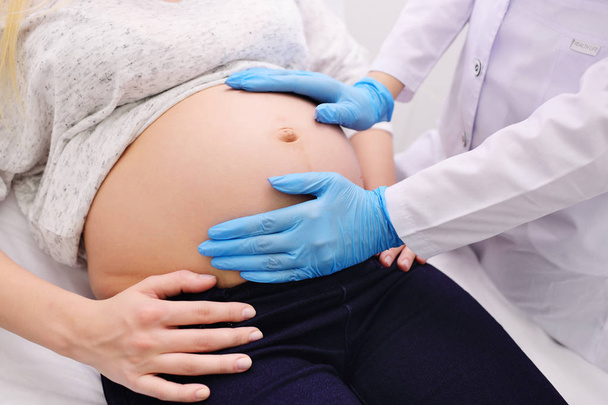 医師の婦人科医を調べて大きな腹を持つ妊婦 - 写真・画像