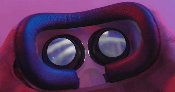 Virtuele realiteit afspelen van video binnen met roze en paars licht  - Foto, afbeelding