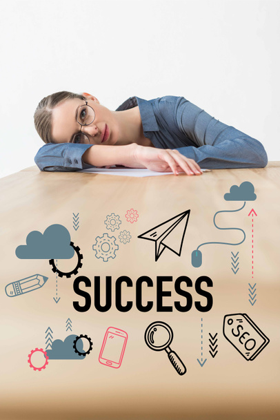 Empresária cansada deitada à mesa no escritório com inscrições de sucesso e ícones de negócios
 - Foto, Imagem
