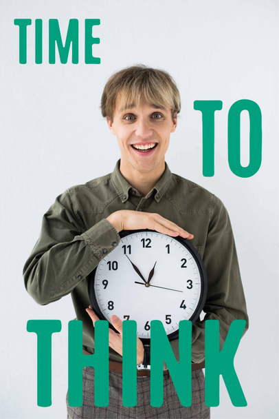 Smiling businessman holding wall clock in hands on white with time to think inscription - Photo, Image
