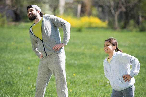 happy father and daughter doing physical exercise in park - Photo, Image