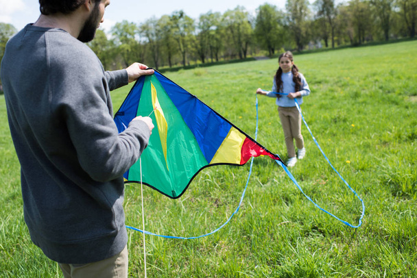 bijgesneden schot van vader kite met dochter houden in park - Foto, afbeelding