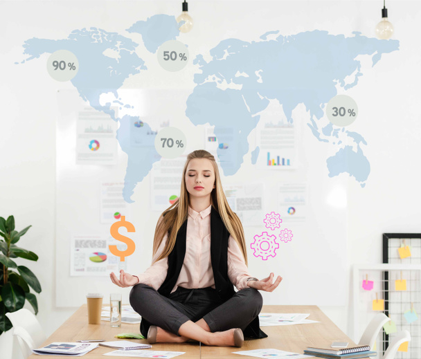 calme femme d'affaires méditant en position lotus sur la table dans le bureau avec signe dollar et rouages dans les mains et carte du monde sur fond
 - Photo, image