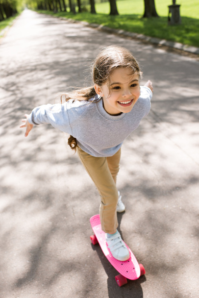 公園でスケート ボードに乗って小さな子供の笑顔 - 写真・画像