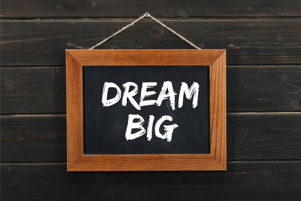 blackboard with dream big inscription hanging on wooden wall  - Photo, Image