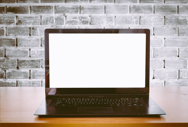 Відкритий ноутбук на офісному столі перед фоном цегляної стіни
 - Фото, зображення