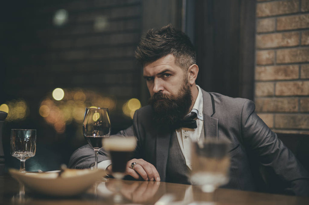portrait of a businessman with glass of champagne over bar background and looking at camera - Foto, Imagem