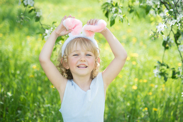 Carino divertente ragazza con orecchie di coniglio divertirsi in giardino
. - Foto, immagini
