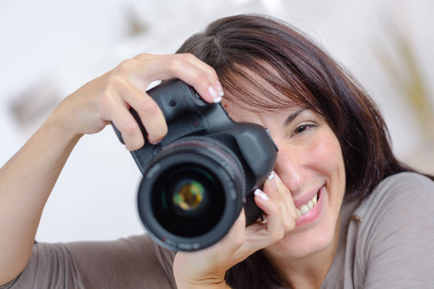 Portrait of woman taking photograph - Foto, afbeelding