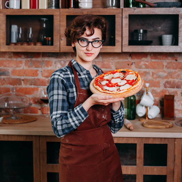 Young woman baker with freshly baked pizza - Photo, Image