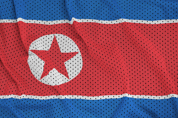 Észak-Korea zászló nyomtatott-ra egy poliészter nylon sportruházat háló fa - Fotó, kép