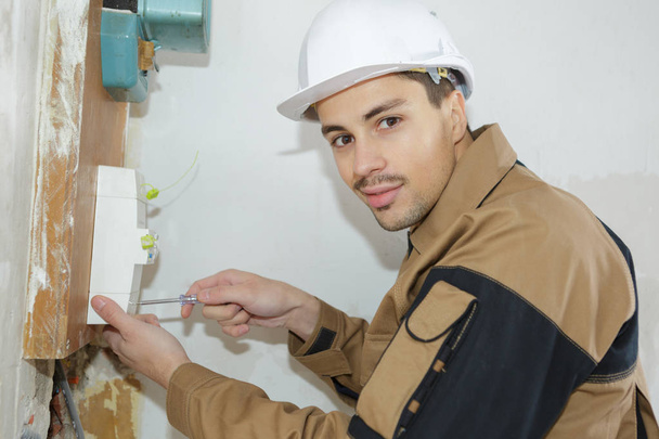 ヒューズ ボックスをインストールする若い電気技師ビルダー エンジニア - 写真・画像