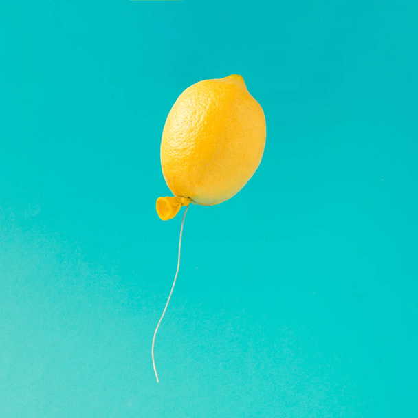 Zitronenballon auf hellblauem Hintergrund. Minimales Sommerspaß-Konzept. - Foto, Bild