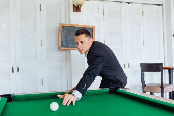 Young handsome man playing billiard game alone - Fotó, kép