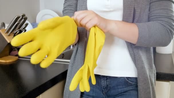 4 k beelden van jonge huisvrouw gele latex handschoenen te dragen terwijl het doen van huishoudelijk werk - Video