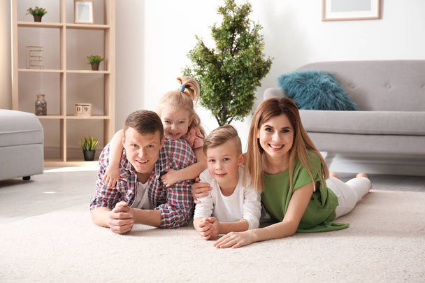 Happy family lying on cozy carpet at home - Foto, Imagen