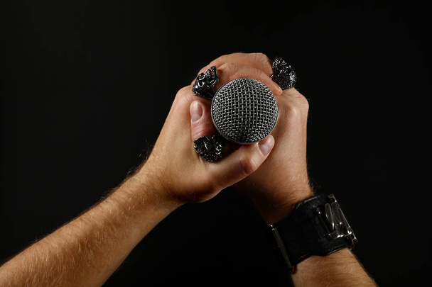 Мужские руки с микрофоном изолированы на черном
 - Фото, изображение