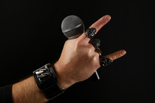 Mano de hombre con micrófono aislado en negro
 - Foto, Imagen