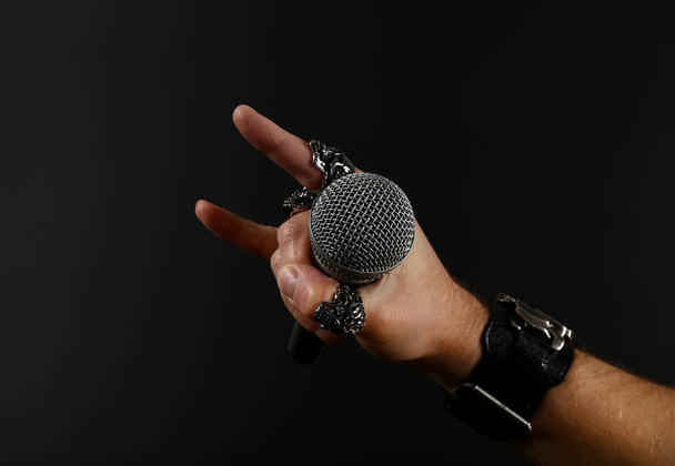 Man hand met microfoon geïsoleerd op zwart - Foto, afbeelding
