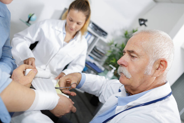 close-up doctor is bandaging upper limb of patient - Foto, Imagen