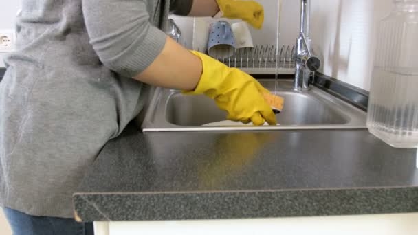 4k panning vídeo de jovem mulher em luvas de altex amarelo lavar pratos na cozinha
 - Filmagem, Vídeo