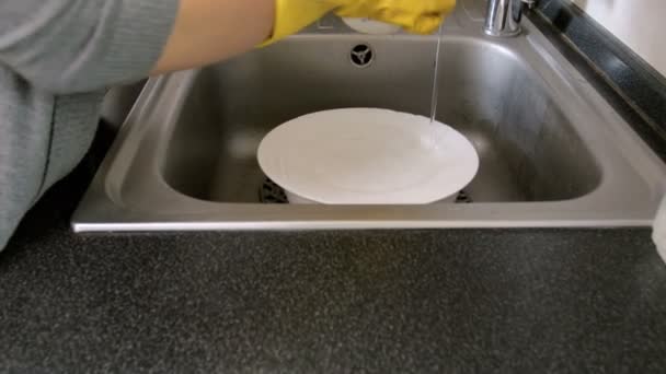 4k крупним планом кадри молодої домогосподарки в захисних латексних рукавичках миття посуду в кухонній мийці
 - Кадри, відео