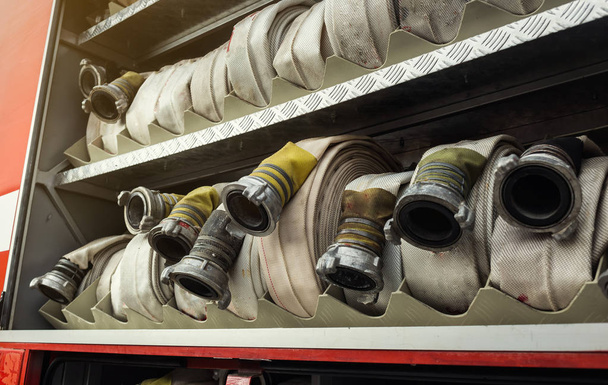 Compartimento de mangueras antiincendios enrolladas en un motor de bomberos. Seguridad de emergencia. Protección, rescate del peligro
. - Foto, imagen